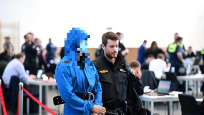 Bild: Udo Güldner
Einer der Angeklagten wird von einem Polizeibeamten in den Gerichtsaal gebracht.