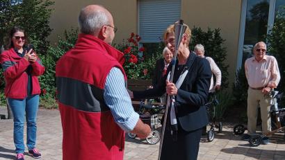 Bild: Janine Schuster/exb
Claus Rättich (im Vordergrund) vom BRK-Kreisverband Nürnberger Land übergibt die Fackel an Oberin Tatjana Richter in Amberg, im Beisein von einigen Bewohnern des Clementine-von-Wallmenich-Hauses.