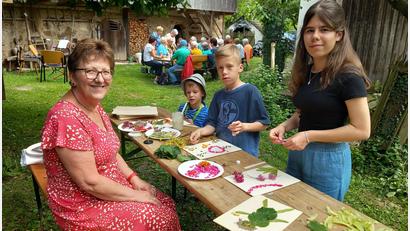 Bild: hka
Elfriede Winter leitet die Kinder beim Basteln an. Klara (rechts), Jakob (Zweiter von rechts) und Elias formten Blüten und Blätter zu bunten Bildern.