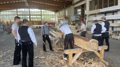 Bild: Michael Kohl/exb
Die Mitglieder des Zimmerervereins Amberg lassen sich in Edelsfeld das traditionelle Behauen von Holzbalken vorführen.