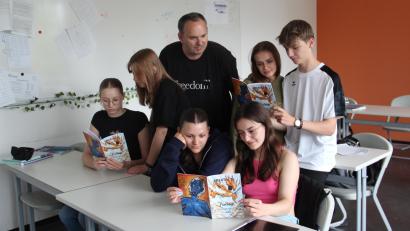 Bild: Stiftland-Gymnasium/exb
Studiendirektor Hans-Jürgen Schmelzer mit Schülerinnen und Schülern bei der Lektüre der Jubiläumsausgabe der "Kreativ".