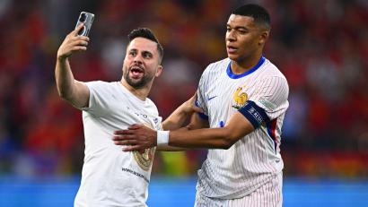 Bild: Tom Weller/dpa
Ein „Flitzer“ ist aufs Spielfeld gelaufen und macht ein Selfie mit Frankreichs Kylian Mbappe (r).