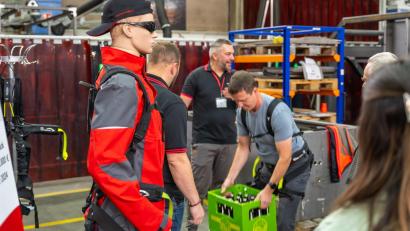 Bild: Horn Glass Industries/exb
Besucher probierten das Heben schwerer Lasten mit einem kraftunterstützenden Exoskelett.
