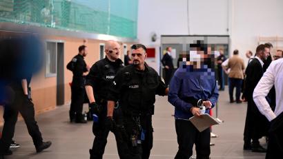 Bild: Udo Güldner
Einer der Angeklagten wird in den Gerichtssaal geführt.