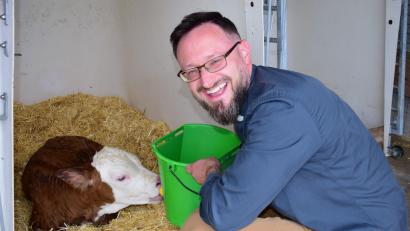 Bild: no
Sichtlich Freude hat Pfarrer Johannes Arweck dabei, dem eine Stunde zuvor geborenen Kälbchen aus einem Nuckeleimer seine erste Milch zu geben.
