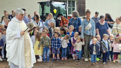 Bild: R. Kreuzer
Pfarrer Thomas Jeschner segnet im Beisein der Kinder den neuen Spielplatz.