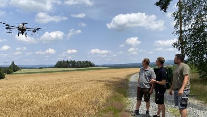 Bild: Judith Zeitler/exb
Kevin Weigl, Fabian Rupprecht und Marc Preuß (von links) beobachten den Flug der Drohne. Ohne Bodenverdichtung kann sie Zwischenfrüchte schon vor der Getreideernte aussäen.