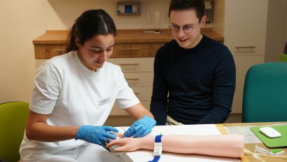Archivbild: kaz
Durch das Projekt Hausarztschmiede soll dem Ärztemangel im Landkreis Tirschenreuth entgegen gewirkt werden. An einem Übungsarm zeigt Dr. Luca Frank Studentin Janine Burger was bei der Blutentnahme zu beachten ist.