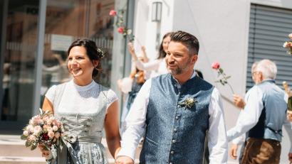 Bild: Kristina Erker/exb
Nach ihrer Trauung in Illschwang gehen Christina Stollner und Marc Simmendinger durch ein Splaier mit Rosen..