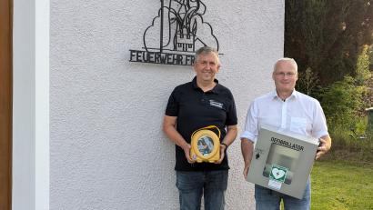 Bild: Winderl
Stellvertretend für das ganze Dorf nahm FFW-Vorsitzender Peter Böckl (links) den Defibrillator von Fördervereinsvorsitzendem Alfons Schmitzer entgegen.