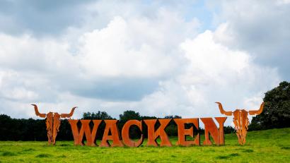 Bild: Daniel Bockwoldt/dpa
Der Schriftzug vom Heavy-Metal-Festival Wacken Open Air steht auf einer Wiese. In der Nacht auf Dienstag hat es auf dem Festival-Gelände gebrannt.