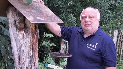 Bild: Rainer Holzapfel 
Bienenexperte Rainer Holzapfel neben einem Bienen-Unterschlupf aus Totholz.