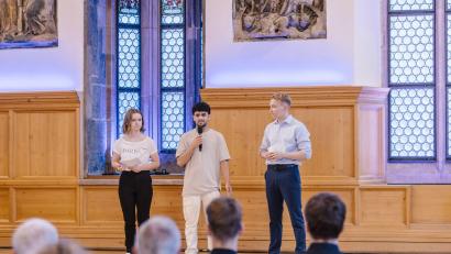 Bild: StMUK/Thomas Langer/exb
Mohabullah (Mitte), Schüler der 11. Klasse an der FOSBOS Amberg, wurde für sein Engagement im historischen Rathaussaal in Nürnberg geehrt.