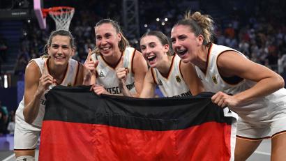 Bild: Sina Schuldt/dpa
Feiern mit der Fahne: Die 3x3-Basketballerinnen.