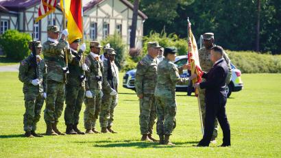 Bild: Bild: US-Armee Garnison Bavaria. 
Director Tommy Mize (recht) übergibt die Truppenfahne von Oberst Kevin Poole an den neuen Kommandeur Oberst Stephen Flanagan als Zeichen des Kommandowechsels.