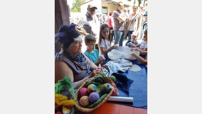 Bild: GGÜ, Autor [GGÜ] (GKGRUENWALD@T-ONLINE.DE)
Eine Filzerin zeigt den Kindern, wie aus gefärbter Schafwolle bunte Filzkugeln entstehen. Die neugierigen Kleinen dürfen selbst ausprobieren.