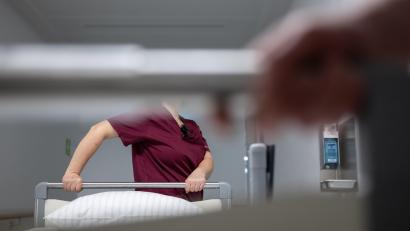 Symbolbild: Marijan Murat/dpa
Eine Krankenpflegerin schiebt ein Krankenbett durch den Gang einer Station eines Krankenhauses.