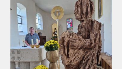 Bild: td
Die Skulptur "Tragen und getragen werden" stellt der Klardorfer Pfarrer Markus Meier (am Altar) in der Klardorfer Kirche St. Georg aus.
