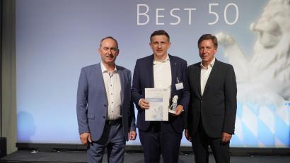 Bild: Fabian Borkner/exb
Wirtschaftsminister Hubert Aiwanger, Maschek-Geschäftsführer Reiner Hochmuth und Jury-Mitglied Professor Thomas Edenhofer vom Wirtschaftsprüfungsbereich der Firma Baker Tilly (von links) zeigt das Bild bei der Preisübergabe bei München.