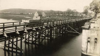 Bild: Stadtarchiv Schwandorf/exb
Für den Neubau 1934 wurde eine Behelfsbrücke errichtet, rechts die Pfeiler der Naabbrücke. Der Blick richtet sich nach Krondorf. Südlich der Amberger Straße stehen nur ein paar Häuser.