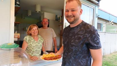 Bild: bsc
„Gabis Currywürste sind die besten“, meint nicht nur Michael Rauh (rechts). Die kleine warme Mahlzeit entwickelte sich in dieser Saison im Freibad Friedenfels zum Renner. Gabi und Gottfried Härtl (von links) wollen auch nächstes Jahr wieder am Ausgabefenster des Kiosk stehen.