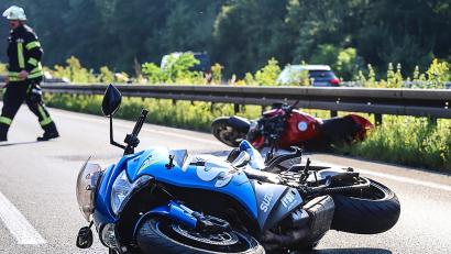 Symbolbild: Alex Talash/dpa
Zwei Motorräder sind an einer Unfallstelle zu sehen.
