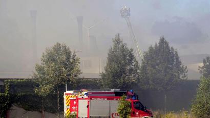 Bild: Daniel Vogel/-/dpa
Feuerwehr vor dem Großbrand in dem Industriegebiet von Wunsiedel. Letzte Glutnester müssen noch gelöscht werden.