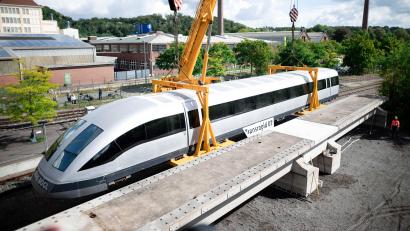 Bild: Fabian Strauch/dpa
Der Transrapid wird vom Tieflader abgeladen und steht vor der zukünftigen Strecke, vorne im Bild. Bochum bekommt den Transrapid. Als neues Exponat wird der Transrapid 07 am Bochumer Eisenbahnmuseum aufgebaut. Das Museum hat das Fahrzeug mitsamt einem Teil seiner Fahrbahn vom Nürnberger Unternehmen Max Bögl, das den Transrapid mitentwickelte, erworben.