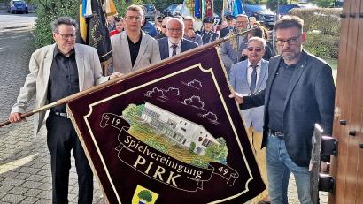Bild: R. Kreuzer
Vorsitzender Josef Schiesl (rechts) und Karlheinz Ströbert (links) ziehen mit der neuen Fahne der SpVgg Pirk in die Kirche. Mitdabei sind viele Mitglieder und Ehrengäste.