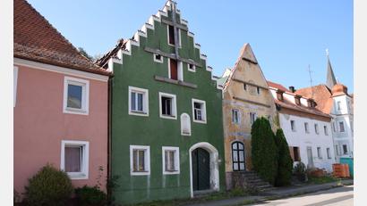 Bild: bö
Für das grüne Haus am Marktplatz in Hohenburg hat das Landratsamt eine Notsicherung angeordnet. Seit dem Großfeuer im Mai 2020 ist bei zwei der betroffenen Häuser nichts passiert, lediglich für das dritte Haus (rechts) ist die Sanierung so gut wie abgeschlossen.