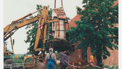 Repro: Archiv Fritsch/exb
Nach langen Verhandlungen einigten sich Landratsamt, Stadt, Kirche und Bauträger auf eine Versetzung des Bildstocks. Den neuen Standort legte die untere Denkmalschutzbehörde ca. 55 Meter östlich des bisherigen fest. In den Tagen vor Pfingsten 1995 wurde das Marterl dorthin mit Hilfe eines großen Autokrans unter großen Sicherungsmaßnahmen umgesetzt.