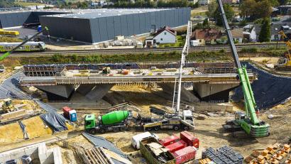 Bild: Wolfgang Erhart/exb
Das Brückenbauwerk mit einer Länge von 63 Metern und einem Gewicht von 4125 Tonnen wird in zwei Etappen unter die Bahnlinie eingeschoben.