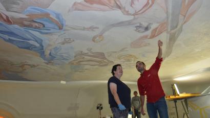 Bild: dob
Kirchenmalermeister Viktor Kaisin von der Firma Fromm aus Parsberg erklärt Mesnerin Monika Krug den nächsten Arbeitsgang am Kirchengewölbe.