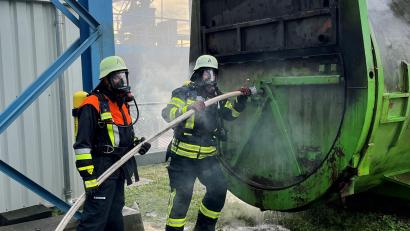 Bild: Franz Grabinger, ZMS/exb
Mit schwerem Atemschutz versuchen die Feuerwehrler beim Übungsszenario beim Müllkraftwerk Schwandorf einen brennenden Container zu kühlen und zu löschen.