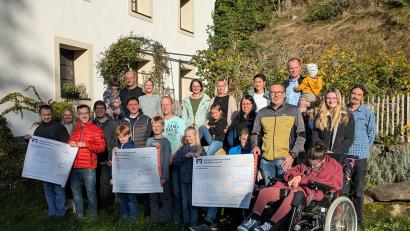 Bild: pz
Die Abordnungen der begünstigten Organisationen mit den symbolischen Schecks - (von links) Wohngruppe St. Gertrud, Sportfreunde Kondrau und "Happynest" - mit den Veranstaltern des Sommerfests vorm Bauerngarten des Stiftlandhofs der Familie Schicker in Hundsbach.