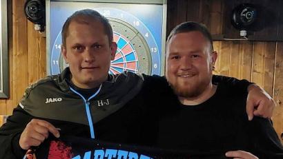 Bild: gz
Der Teamcoach Hans-Jürgen Bauer übergibt Julian Burger aus Waldsassen das neue Trikot der Dartfreunde.