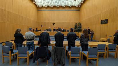 Bild: Wolfgang Würth
Aufstehen zum Auftakt: die beiden Angeklagten mit Dolmetscherinnen und den Verteidigern Rouven Colbatz (Dritter von links) und Matthias Haberl (Dritter von rechts).