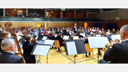 Bild: lg
Das Orchester mit Dirigent Michael Falk und im Hintergrund das konzentrierte Publikum des Jubiläumskonzerts.