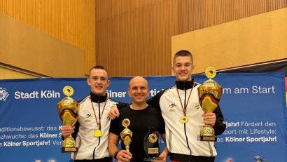 Bild: Manuel Propp
Die Sieger Eric Propp (links) und Dietrich Hermann (rechts) mit ihren Pokalen für den Titel und ihre Leistungen als besten Kämpfer beziehungsweise besten Techniker und ihrem Trainer Ruslan Schönfeld.