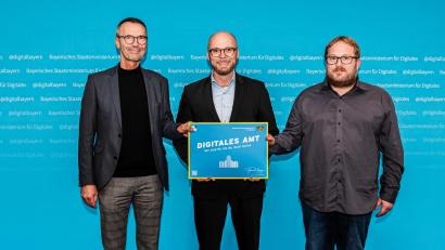 Bild: Staatsministerium Digitales
Bürgermeister Peter Achatzi (links) und der Verwaltungsfachangestellte Simon Bohun freuen sich über die Auszeichnung "Digitales Amt", die ihnen von Bayerns Digitalminister Dr. Fabian Mehring (Mitte) überreicht wurde.