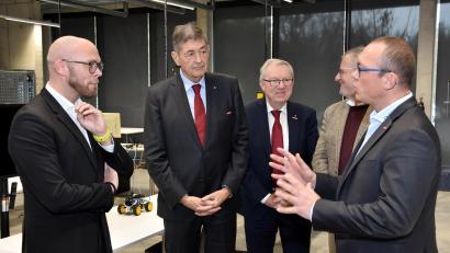 Bild: Fotostudio Schwarz/exb
Uli Götz (rechts), Leiter des Schwandorfer Bildungszentrums, stellt den Gästen – hier zusammen mit Staatsminister Fabian Mehring, Handwerkskammer-Präsident Georg Haber, Handwerkskammer-Hauptgeschäftsführer Jürgen Kilger und Schwandorfs Oberbürgermeister Andreas Feller (von links) – die technische Ausstattung des Zentrums für digitale Gebäudetechnik vor.