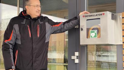 Bild: Josef Glas
Bürgermeister Ludwig Gürtler zeigt den Standort des Defibrillators am Eingang des Schulgebäudes.