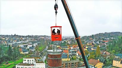 Bild: Stefan Rosenbaum/ESM/exb
Nur an einem Kranseil baumelnd, können Bezirkskaminkehrermeister Boris Kowalewski (rechts) und sein Geselle Janik Fuchs den 45 Meter hohen Kamin am Benker-Areal in Marktredwitz reinigen.