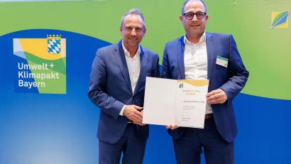 Bild: Ralf Rödel/exb
Bayerns Umweltminister Thorsten Glauber überreicht die Umweltpakt-Urkunde an EMZ-Geschäftsführer Andreas Weidmüller (rechts).