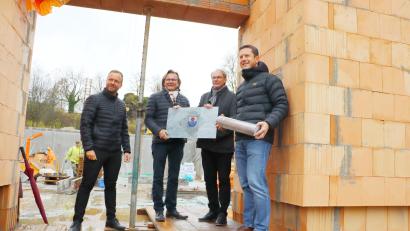 Bild: gru
Bürgermeister Jörk Kaduk (rechts) bringt die Büchse mit Plänen, Bauantrag und der Tageszeitung zur Grundsteinlegung. Zeugen sind (von links) Landtagsabgeordneter Bernhard Heinisch, Architekt Wolfgang Brummer und Jürgen Pickel von der Baufirma.