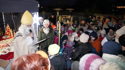 Bild: fvo
Der Heilige Nikolaus taucht beim Adventsmarkt der Freien Wähler aus der Dunkelheit am Hostauplatz in Waldthurn auf und verteilt Geschenke. Insbesondere dankt er Manuela Grünauer und den CantiKids für ihr musikalisches Engagement bei der Veranstaltung.