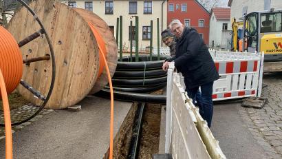 Bild: upl
Leitungsbau in der Dorfstraße: Norbert Arnold und Hans Bäumler schauen auf der Baustelle nach dem Rechten. Schwarz ist die Leitung für die Nahwärme, orangefarben für Glasfaser.