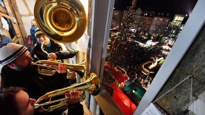 Symbolbild: Martin Schutt/dpa
Blasmusiker spielen für die Besucherinnen und Besucher eines Weihnachtsmarktes.