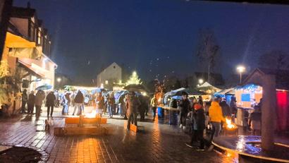 Bild: Dietmar Auers
Trotz Regenwetters bietet der 20. Traßlberger Dorfadvent einen stimmungsvollen Anblick, wie hier der festlich geschmückte Dorfplatz mit Christbaum, wärmenden Feuerstellen und geselligem Treiben.