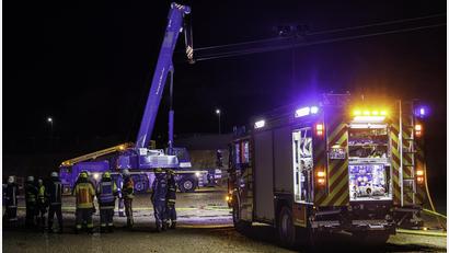 Bild: Hösamer
Der Haken eines mobilen Schwerlastkrans hat sich am Montagabend in einer Hochspannungsleitung im Stullner Industriegebiet verfangen. Die Einsatzkräfte von Feuerwehr und THW warten darauf, dass der Strom sicher abgeschaltet wird und sie eingreifen können.